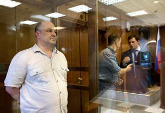 Former GRU employee Gennadii Kravtsov (left) during sentencing in a Moscow court.