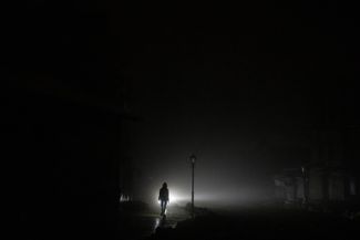 Женщина идет по центру Киева во время отключения электричества