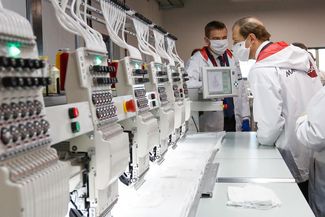 Russia’s Industry and Trade Minister Denis Manturov and his deputy Viktor Evtuhov (left) inspecting the production line at the Bosco factory in Kaluga, which has launched production of protective masks. April 22, 2020.