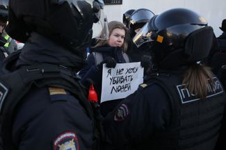 Полицейские задерживают женщину с плакатом «Я не хочу убивать людей» во время несанкционированного антивоенного митинга в Москве. 6 марта 2022 года