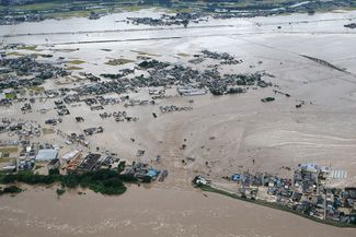 Потоком воды из реки Кинугава затопило жилые районы городе Дзесо в префектуре Ибараки, 10 сентября 2015 года
