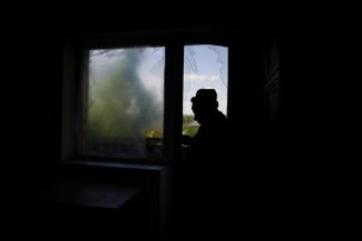 Клавдия Тищенко смотрит из окна своего дома в Ирпене, уничтоженного в результате артиллерийского обстрела российскими войсками