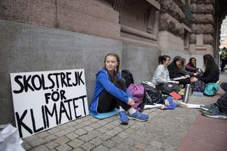 Грета Тунберг в знак протеста против климатического кризиса прогуливает школу — и сидит у стен шведского парламента с плакатом «Школьная забастовка за климат». Август 2018 года