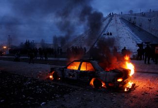 Горящий автомобиль в центре Тираны после протестов оппозиции 2011 года