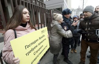 An activist outside the State Duma demands that Leonid Slutsky be held responsible for sexually harassing journalists. March 21, 2018
