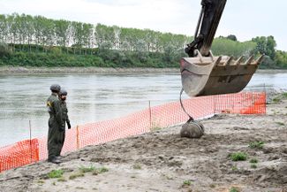 Итальянские военные убирают бомбу времен Второй мировой войны, обнаруженную в пересохшей реке По. 7 августа 2022 года