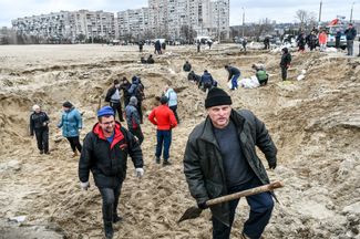 Местные жители наполняют мешки с песком. Их используют для укрепления блокпостов на дорогах, ведущих в Киев