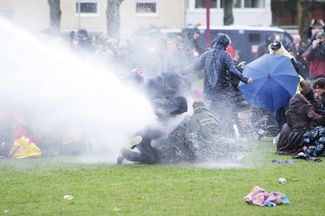 Полиция Амстердама применяет водометы против участников акции протеста, выступающих против антиковидных мер, введенных в Нидерландах, 24 января 2021 года