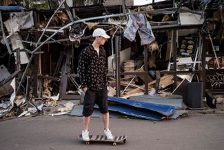 Житель Краматорска едет на скейтборде мимо разрушенного ракетным ударом магазина