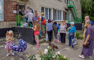 Харьковчане, живущие недалеко от линии фронта, стоят в очереди за едой, которую готовят волонтеры<br>