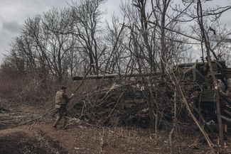 Украинские солдаты маскируют свою технику среди деревьев