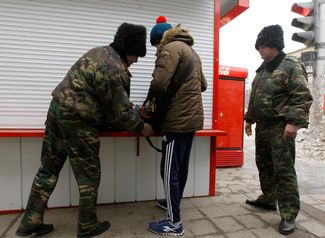 Патруль казаков проверяет вещи прохожего во время рейда по предотвращению терактов в Волгограде, 2014 год