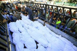 Грузовик с телами палестинской семьи Абу аль-Ауф, завернутыми в погребальные саваны. Семья эвакуировалась с севера сектора Газа в город Дейр-эль-Балах и была убита в доме, где проживали внутренне перемещенные палестинцы. 15 октября 2023 года