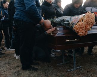 Valeriy Kozyr cries on the coffin of his daughter, Olha.