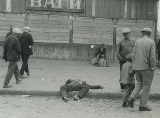 Прохожие идут мимо тела мужчины, умершего от голода. Харьков, 1932 год