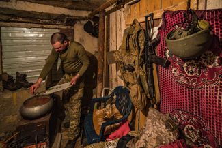 Украинский солдат готовит ужин в подвале