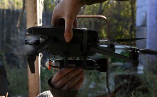 Украинские военные в Бахмуте снаряжают коммерческий коптер с системой сброса самодельными боеприпасами. Сентябрь 2022 года