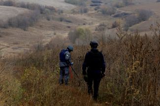 Украинский пожарный из отряда разминирования сканирует землю в селе Русская Лозовая. Октябрь 2022 года