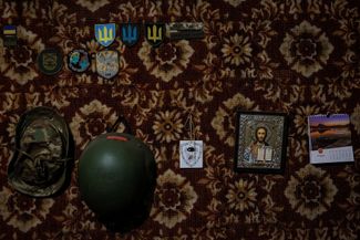 Шевроны, каска и икона на стене во временном расположении украинских бойцов в Донецкой области