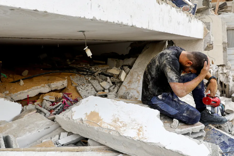 Спасатель плачет среди завалов в Рафахе