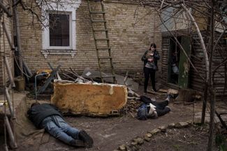 Жительница Бучи и тела ее погибших мужа и брата, убитых во дворе их дома