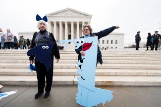 Активисты, выступающие против джерримендеринга, в костюмах 5 и 1 избирательных округов штата Мэриленд, протестуют против перенарезки избирательных округов штата у здания Верховного суда США. Вашингтон, 28 марта 2018 года