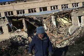 Пожилая жительница Краматорска возле здания школы, в которую попала российская ракета
