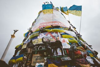 Участники протестов забрались на елку на Майдане Незалежности во время проведения народного вече. 8 декабря 2013 года.