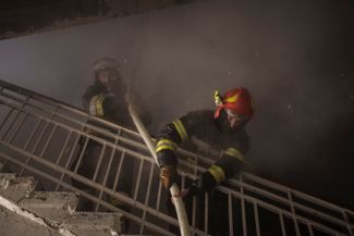Пожарные тушат огонь в здании, загоревшемся от обстрела Харькова российскими войсками.<br>