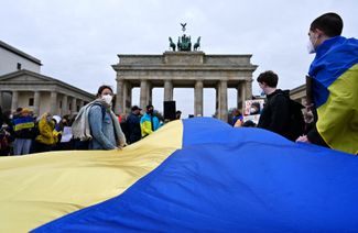 В Берлине протестующие против вторжения российских войск в Украину вынесли на Парижскую площадь огромный украинский флаг