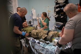Военные врачи оказывают первую помощь раненым украинским бойцам в медпункте под Бахмутом