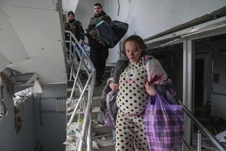 Marianna Podgurskaya walking down a flight of stairs at the maternity hospital after the bombardment. Mariupol, March 9, 2022. 