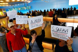 Протестующие в аэропорту Лос-Анджелеса. В руках у них листы с именами тех, кому запретили въезд после указа Дональда Трампа