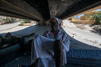 Мигрант прячется под мостом от палящего солнца. 27 июня 2022 года, Мелилья (Испания)