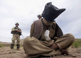 Американские солдаты присматривают за пленными во время операции «Ярость дракона» по поимке членов «Талибана» в провинции Пактия. 2 июня 2003 года