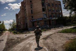 Украинские снайперы выходят на позицию для стрельбы в Марьинке на окраине Донецка, следуя целеуказанию с дрона. Май 2022 года