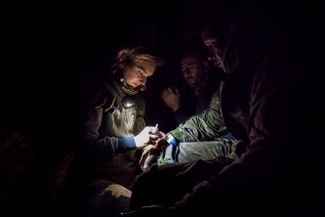 Украинский врач помогает раненому солдату, попавшему под российский обстрел