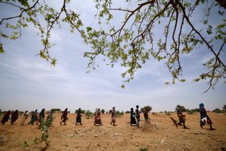 Суданские беженцы в очереди за гуманитарной помощью от Всемирной продовольственной программы (WFP) на границе Судана и Чада, 9 мая 2023 года