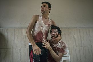 Два брата Эль Ага оплакивают отца, убитого во время артобстрела города Хан-Юнис, южная часть Газы, июль 2014 года