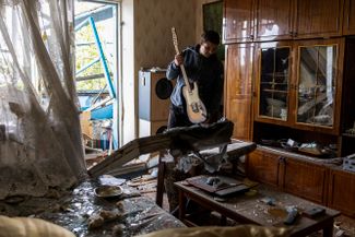 Житель Николаева разбирает вещи в своей квартире после ночного ракетного удара со стороны России по жилым кварталам города