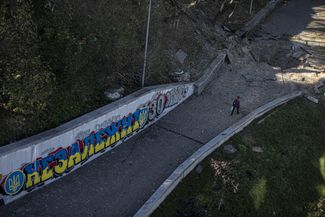 Разрушенный при обстрелах тротуар и граффити в Киеве
