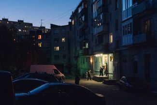 A view of the city of Murmansk at dusk. People coming out of a café.