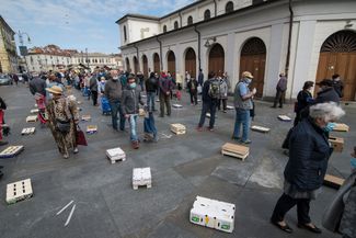 Люди в очереди на центральном рынке Турина. 4 мая 2020 года