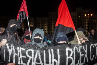 Белорусские анархисты несут растяжку «Тунеядцы всех стран соединяйтесь» во время «Марша рассерженных белорусов» в Минске 17 февраля. После акции сотрудники милиции в штатском попытались задержать активистов, но им удалось скрыться на общественном транспорте