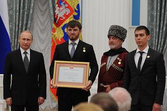 Islam Kadyrov (with the award) and Russian President Vladimir Putin (left)