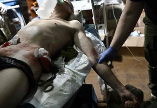Врачи из пятой штурмовой бригады помогают раненому украинскому военнослужащему в районе Бахмута