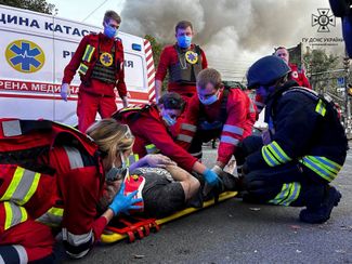 Сотрудники скорой помощи укладывают на носилки раненого жителя Черкасс