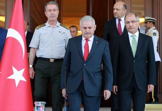 Премьер-министр Турции Бинали Йылдырым (в центре), глава Генштаба Хулуси Акар (слева) и министр внутренних дел Афкан Ала (справа) перед пресс-конференцией в Анкаре. 16 июля 2016 года.