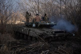 Бойцы ВСУ едут на танке Т-64 на передовой под Бахмутом. Армия РФ захватила город после многомесячных боев в мае 2023 года, но на этом направлении в Донецкой области по-прежнему идут боевые действия