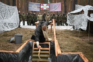 Священник РПЦ Николай Гвоздев освящает воду во время празднования Крещения на позициях российской армии